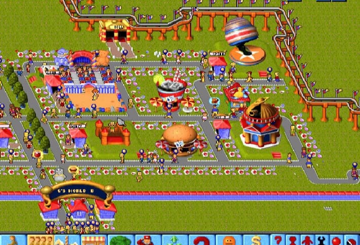 Парк в Theme Park сверху: дорожки с посетителями, ларёк в виде огромного стакана колы, бургерная, надувной замок, сверху и справа петляет американская горка, внизу арка входа