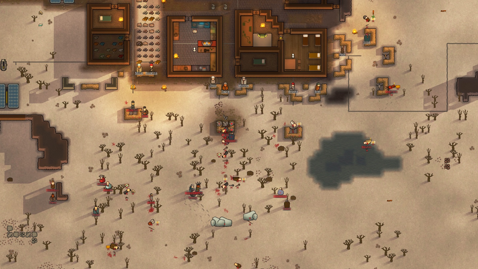 RimWorld, вид сверху: колонисты держат оборону за мешками с песком у стен домов, на пустом поле среди сухих деревьев лежат и прячутся нападавшие с красными именами, над полем дым